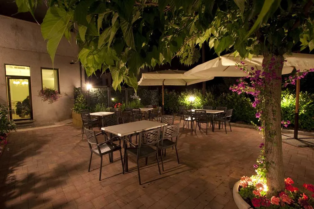 Sala del ristorante La Lumaca d'Oro con tavoli preparati per la cena e illuminazione calda