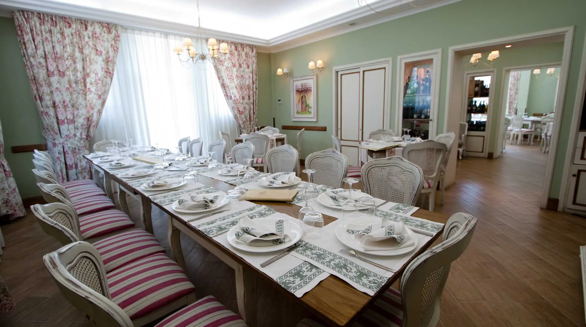 Sala del ristorante La Lumaca d'Oro con tavoli apparecchiati, sedie in legno e pareti chiare